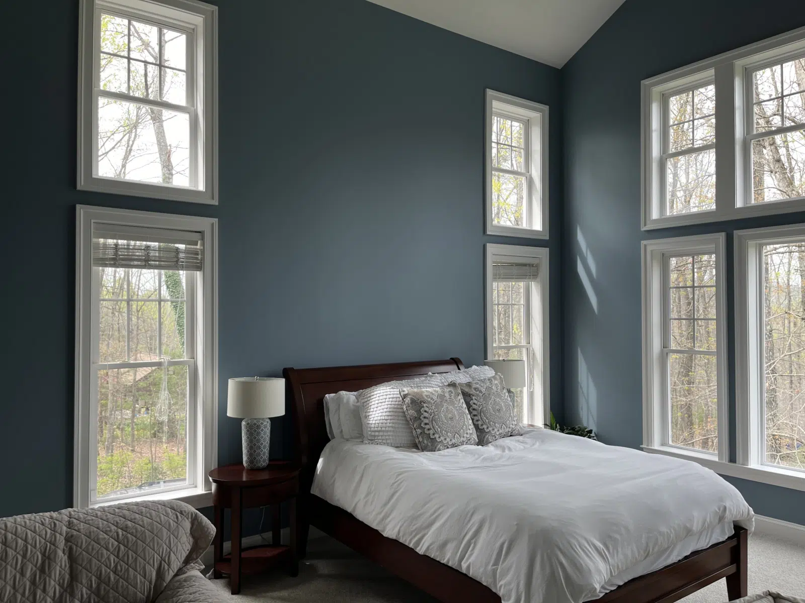 Bedroom with blue accent walls and tall white-trimmed windows — Alvarez' Painting in Charlottesville